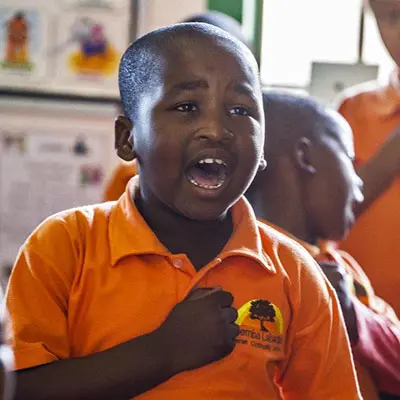 Südafrika: Junge im iThemba Labantu-Tshirt singt stolz.
